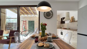 A modern dining area with a wooden table, clear chairs, and a large window overlooking a garden. - Villa Nascosta with Private Pool, Sauna and en-suite bathrooms (Vodnjan)