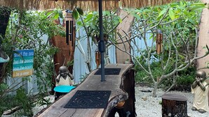 A wooden pathway leading through a garden with a sign that reads "smell the sea, feel the breeze, hear the ocean, be at ease." - Akuli By The Sea Unit 2 (Iluka)