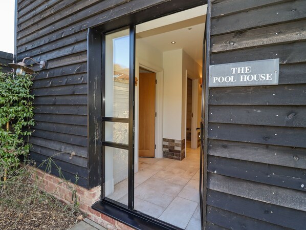 A wooden building with a sign reading "THE POOL HOUSE". - The Millhouse (Ledbury)
