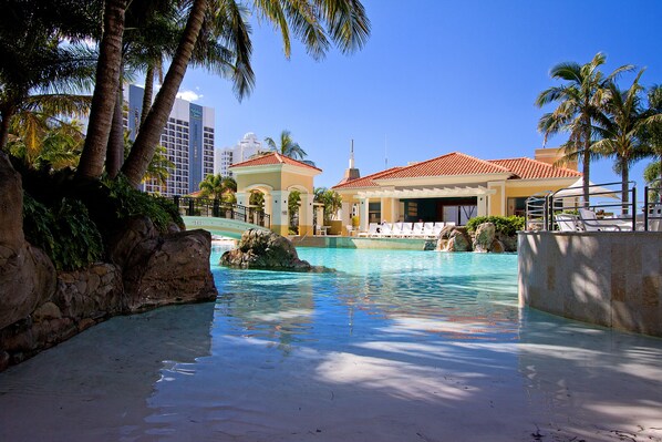 Relax by the serene pool surrounded by lush palm trees and a well-maintained landscape.