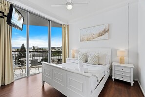 Relax in this stylish bedroom with a large bed, flat-screen TV, and balcony offering a city view.