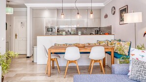 A modern kitchen with white cabinets, a central island, and pendant lighting.