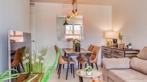 Una sala de estar moderna con comedor, un sofá, una mesa de centro y una lámpara.