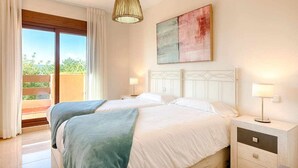 Una habitación doble con balcón, un ventanal grande y un cuadro en la pared.