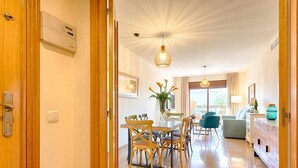 Una sala moderna con comedor, sofá y televisor.