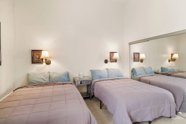 Bedroom with two beds and wall sconces