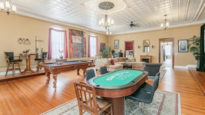 A spacious living room with a pool table, a billiards table, and a comfortable seating area.