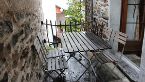 A stone wall with a metal railing and a wooden bench.