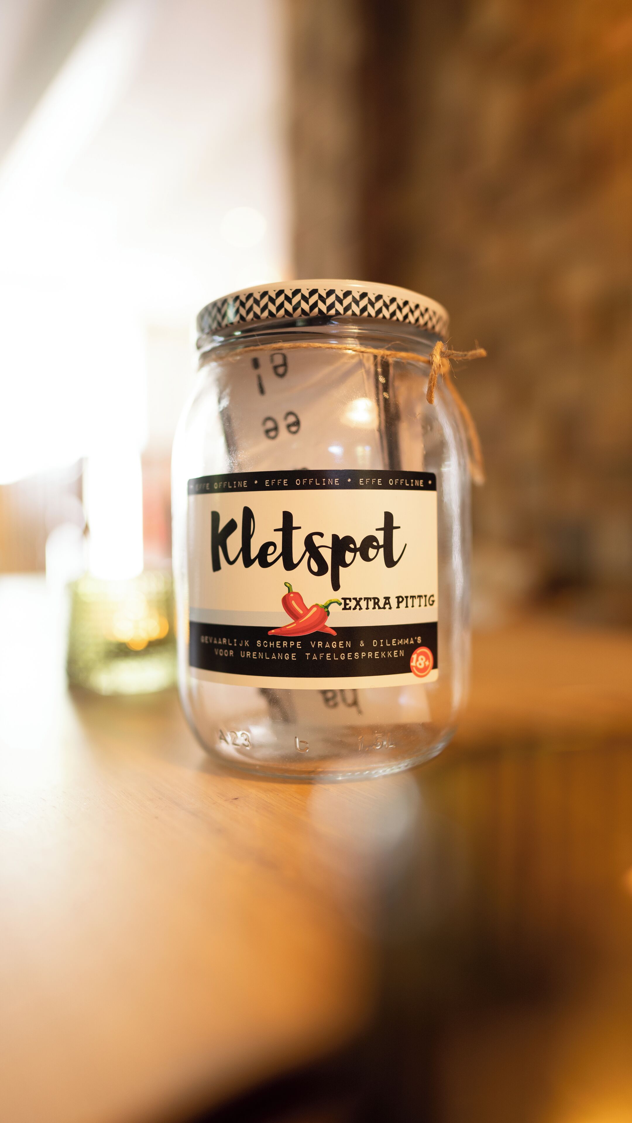 Un barattolo etichettato 'Kletspot' con un'illustrazione di peperoncino, su un piano di legno.
