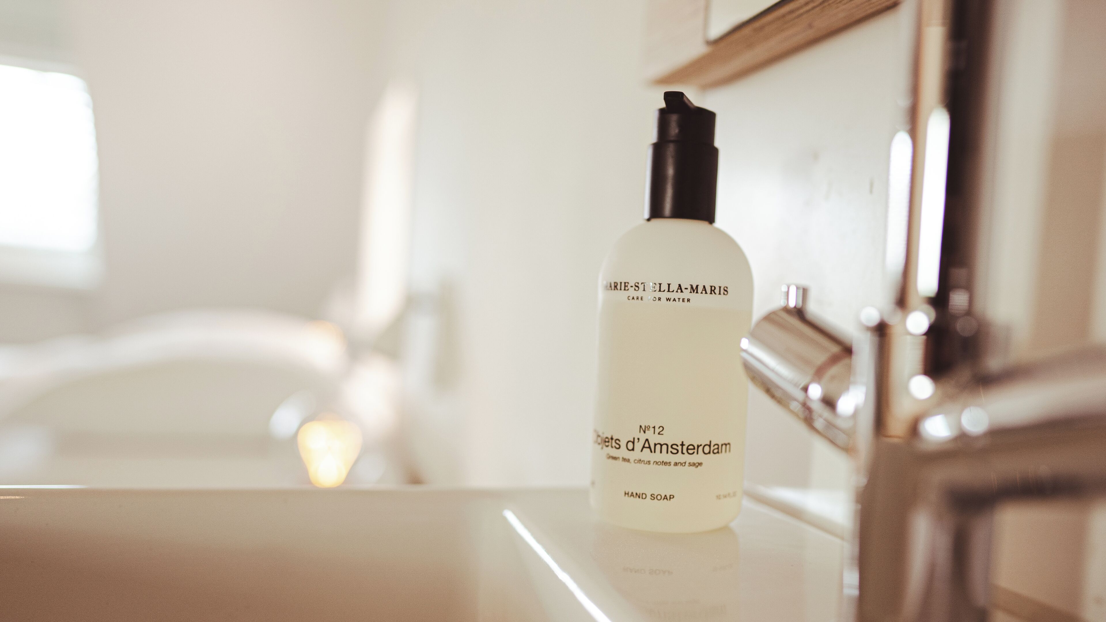 A bottle of hand soap on a bathroom counter.