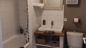 A bathroom with a bathtub, a sink, a toilet, and a shower.