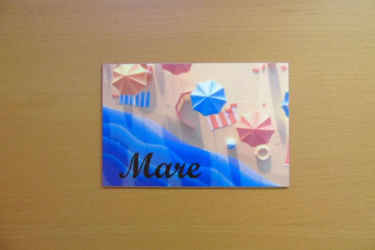 A small, square, wall-mounted item with the name "Mare" and various origami shapes.