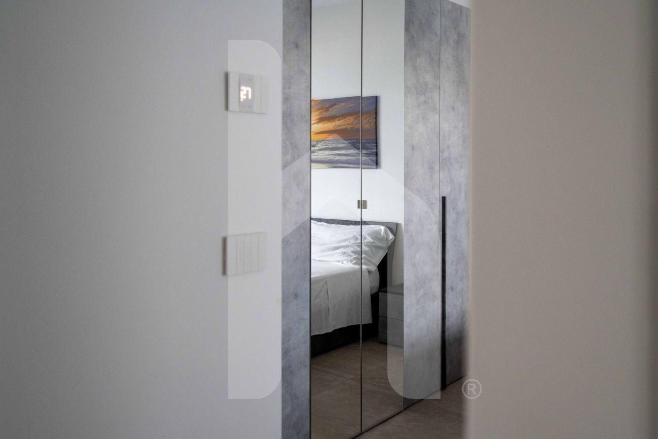 A bedroom with a bed, a nightstand, and a painting on the wall.