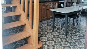 A wooden staircase leading to a loft area with a kitchen and dining space.