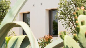 Un edificio moderno con dos ventanas y una pared de piedra al frente.