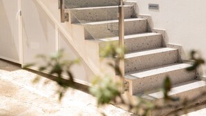 Una escalera con barandillas de vidrio que conduce a un piso superior.