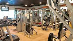 A gym with various exercise equipment, including treadmills, weight machines, and free weights. - Peninsula Links B102 (Gulf Shores)