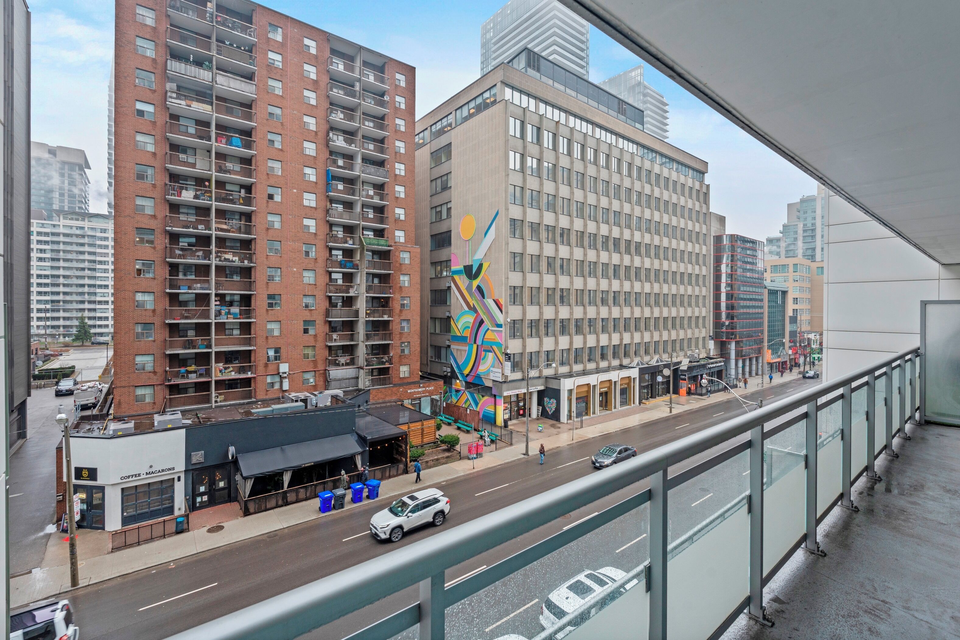 Un edificio de varios pisos con una gran escultura abstracta y colorida en primer plano.
