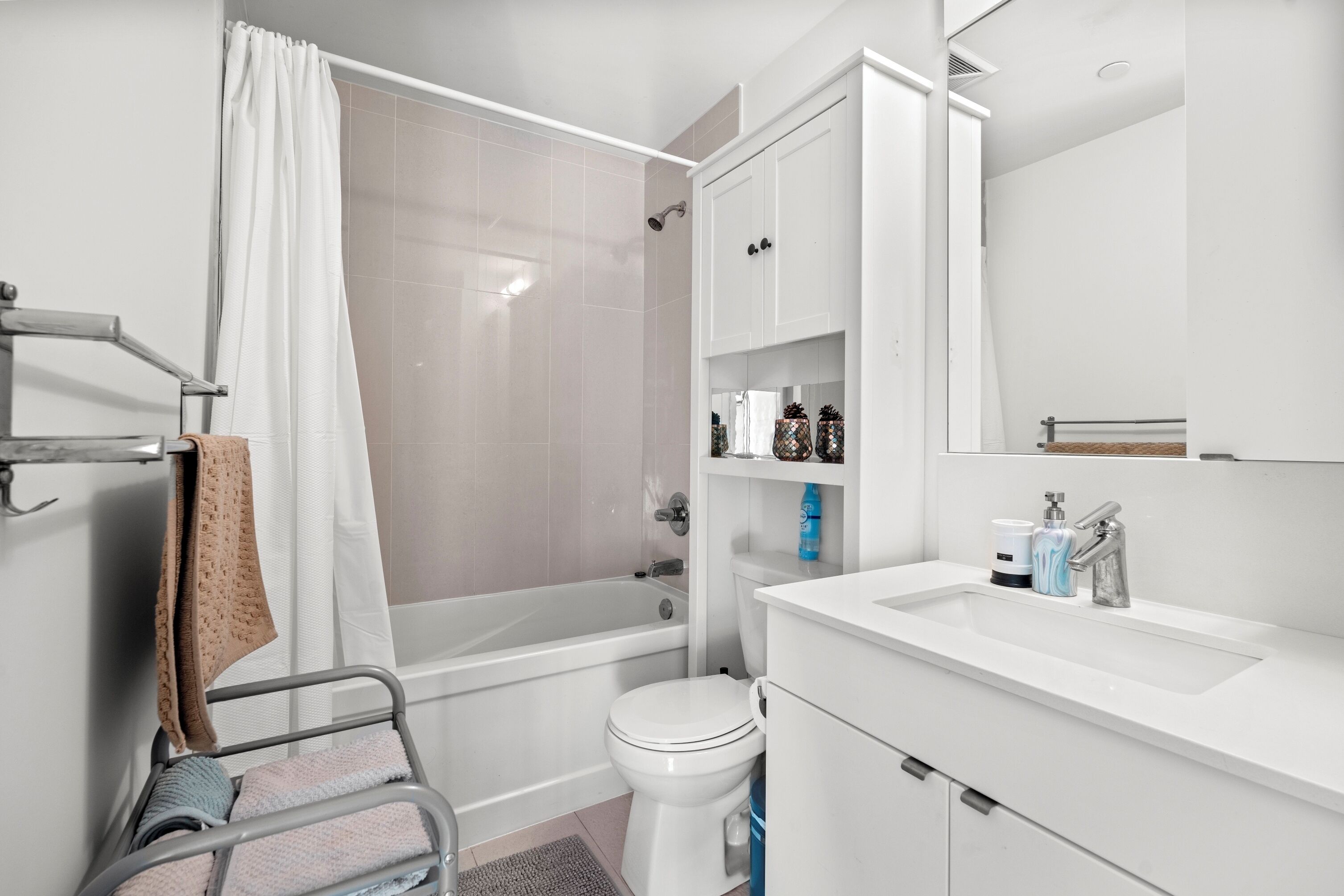 A modern bathroom with a bathtub, toilet, and sink.