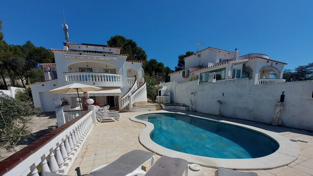 A swimming pool with lounge chairs, a staircase, and a building with balconies. - 5 bedroom villa in l'escala (L'Escala)