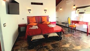 Une chambre avec un grand lit, un bureau et une chaise.