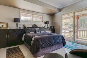 Relax in a stylish bedroom with a large bed, wardrobe, and a side table with a lamp.
