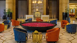 A lobby with a central seating area, a chandelier, and a reception desk. - Taj Gandhinagar Resort & Spa (Mansa)