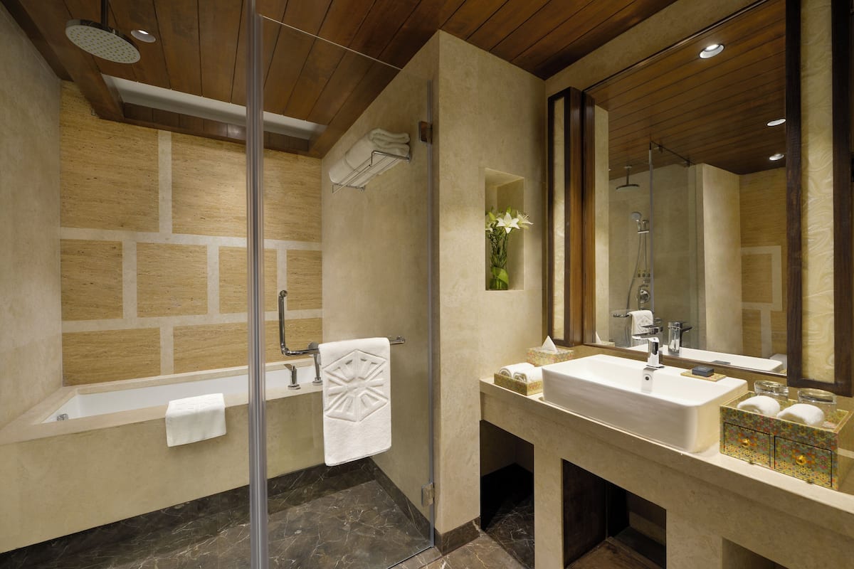 A modern bathroom with a bathtub, shower, and sink.