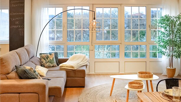 A cozy living room with a sofa, a round rug, a table with a glass, and a potted plant. - Stunning apartment in Vimianzo with WiFi (Vimianzo)