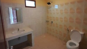 Ein Badezimmer mit Waschbecken, Spiegel, Toilette und Dusche.