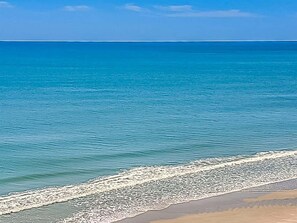 Una playa con agua cristalina y una orilla arenosa.
