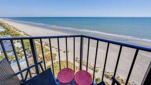 Een balkon met uitzicht op een strand en de oceaan.