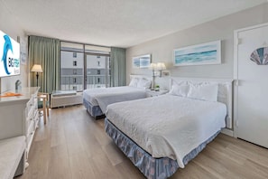 A hotel room with two beds, a desk, a chair, a lamp, and a view of the outside. - Sand Dunes Ocean Direct View 7th Flr, Great Pools! (Myrtle Beach)