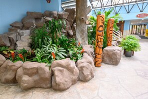 Escape to a serene oasis amidst lush tropical plants and natural stone formations.