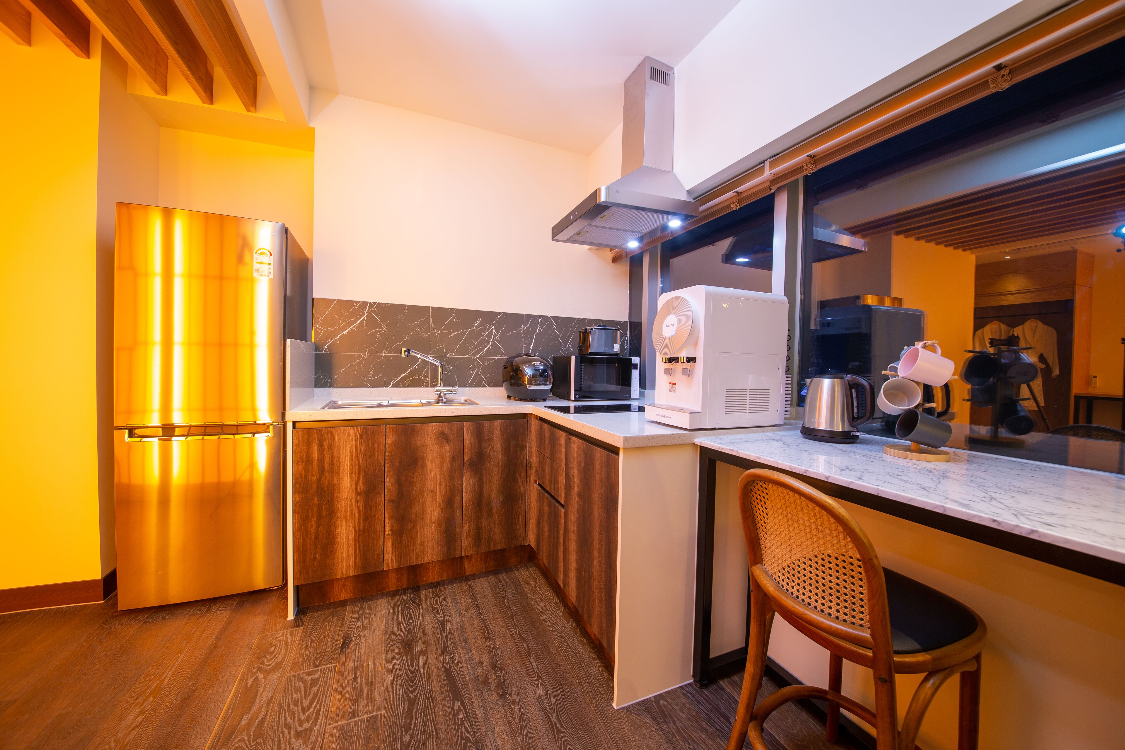 A modern kitchen with a built-in oven, microwave, and coffee maker.