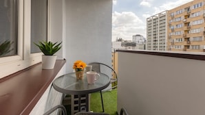 A balcony with a small table, two potted plants, and a chair. - Comfortable Apartment in the Center | Balcony and Air Conditioning (Warszawa)