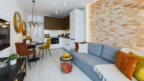 Un salon moderne comprenant un canapé, un coin repas et une cuisine.