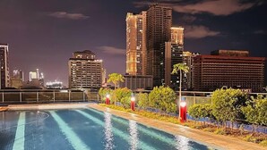 A swimming pool with a cityscape in the background. - Malate Bayview Mansion (Manila)