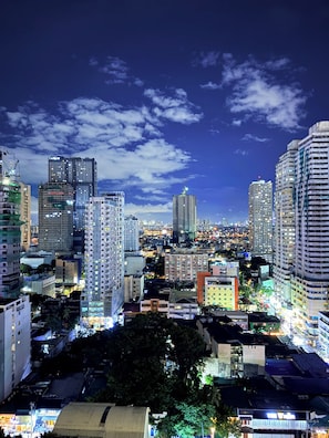 A cityscape at night with high-rise buildings, including a prominent 'CITYLAND' building. - Malate Bayview Mansion (Manila)