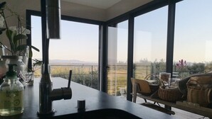 Una cocina moderna con un amplio ventanal que da a un balcón con mobiliario de exterior.