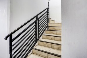 A staircase with black metal railings and beige steps.