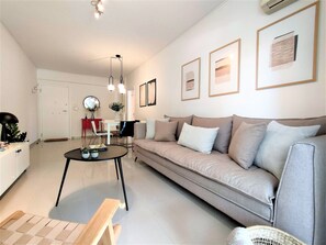 Un salon moderne comprenant un canapé, une table basse et un coin repas avec une table et des chaises.