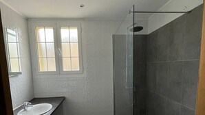A bathroom with a glass-enclosed shower, a white sink, and a window with frosted glass. - Studio 30 m2 Dans Petit Port de Pêche (Centuri)