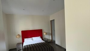 A modern hotel room with a large bed, a red headboard, and two bedside tables with lamps. - Studio 30 m2 Dans Petit Port de Pêche (Centuri)