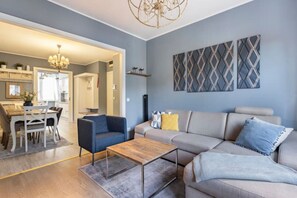 Un salon moderne comprenant un canapé, une table basse et un coin repas avec une table et des chaises.