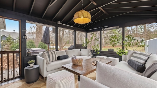 A covered outdoor seating area with a sofa, chairs, a coffee table, and a hanging light fixture. - Updated, Hot Tub, Walk to Union Pier (Union Pier)