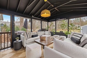 A covered outdoor seating area with a sofa, chairs, a coffee table, and a hanging light fixture. - Updated, Hot Tub, Walk to Union Pier (Union Pier)