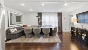 A modern living room with a dining area, a sofa, a TV, and a fireplace. - Updated, Hot Tub, Walk to Union Pier (Union Pier)