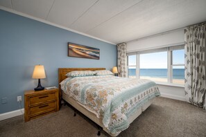 A bedroom with a bed, two bedside tables, a window with curtains, and a painting on the wall. - Beautiful two bedroom, 2 bath condo in desirable North OC with great views! (Ocean City)