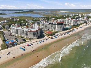 A coastal hotel area with beachfront properties, a sandy beach, and a view of the ocean.